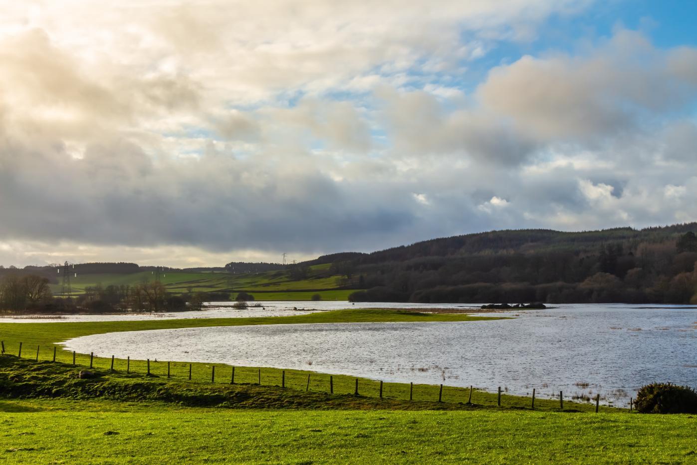 Images shows Loch Ken flooded across green fields near the village of Parton