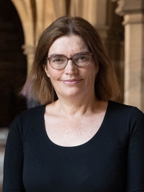 Head and shoulders photo of Nicola McEwan in the Victorian cloisters at the University of Glasgow