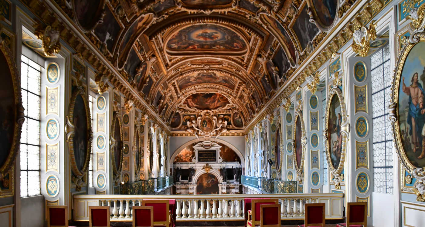 Interior view of a room in Fontainebleau chateux. The room has a highly ornate ceiling, walls and carpet [Photo: Shutterstock]