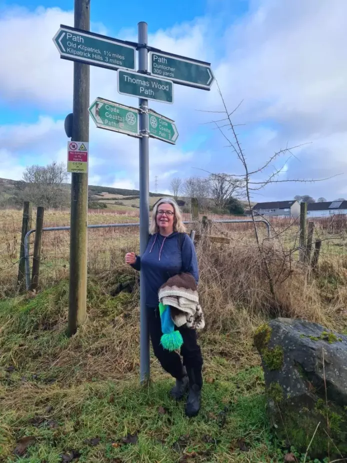 Kat Jones next to signpost for Thomas Wood Path