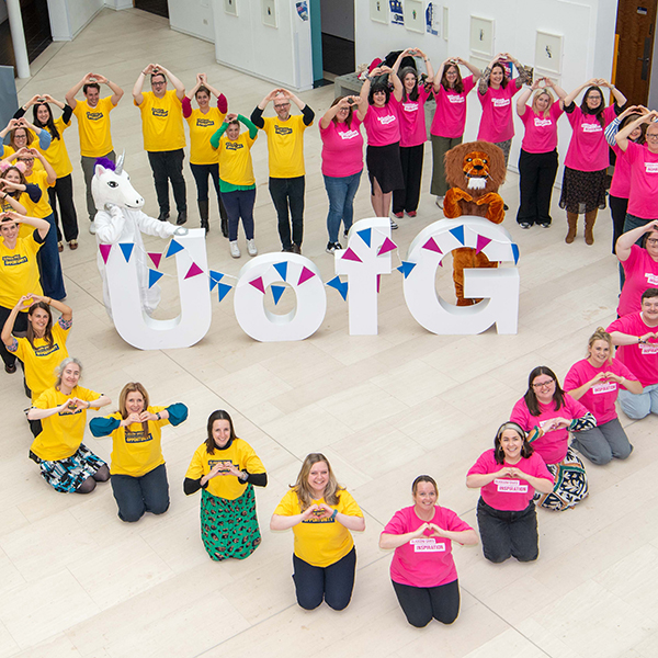 DAO staff sitting in a heart shape with UofG letters in the middle