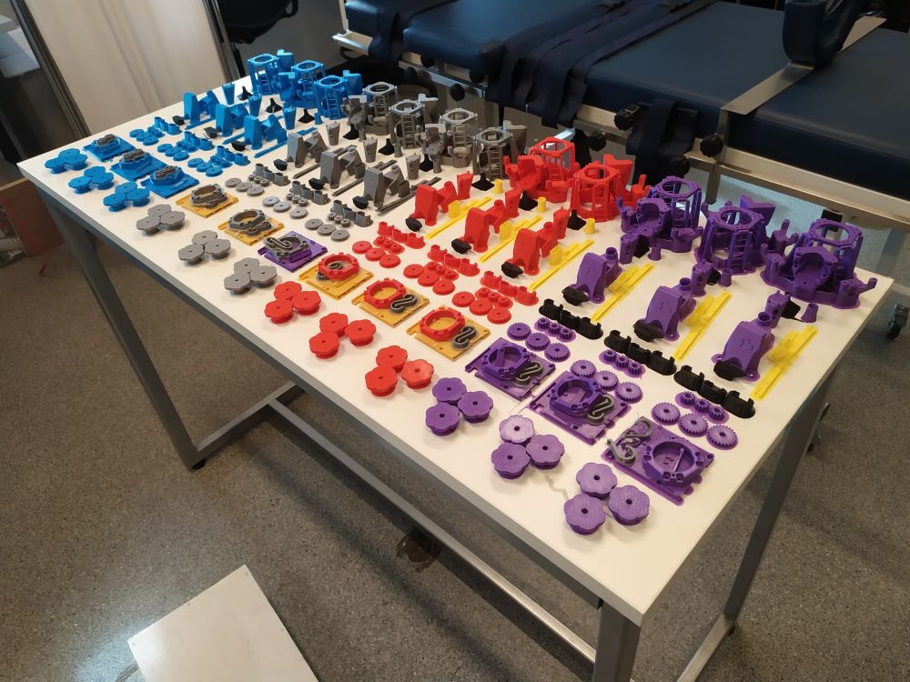 A table covered with small 3D printed items of different colours