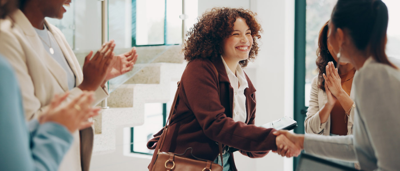 A happy woman shaking hands with new colleagues