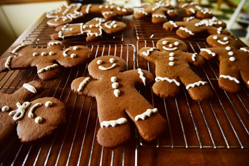 Photo of gingerbread men decorated with white icing on a wire cooling rack