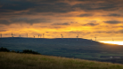 Image of a sunrise and wind turbines on hills in Scotland