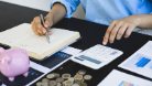 Person with notebook and calculator and money at desk