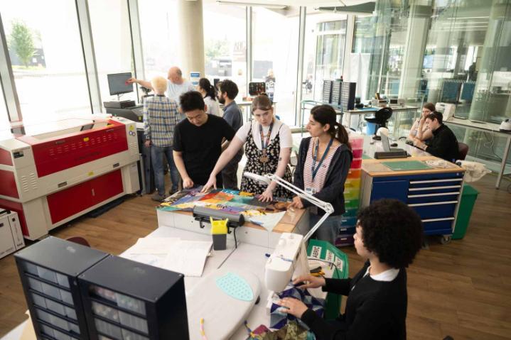 A group discussing vinyl cutting in the maker space