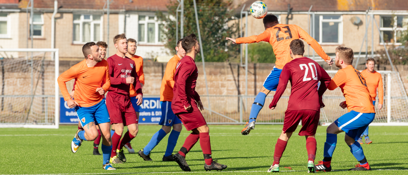 A player jumps to head the ball in an amateur football match