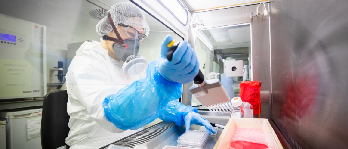 Scientist pipetting in a fume cupboard