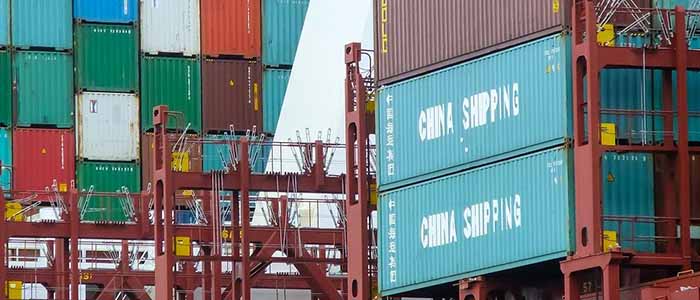 Many shipping containers on top of each other at a docks including several labelled China Shipping. Image credit: Sybille Reuter | iStockphoto https://www.istockphoto.com/photo/cargo-containers-at-a-commercial-dock-terminal-at-hamburg-harbor-germany-gm1222255550-358595066