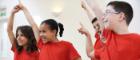 Kids in red t-shirts who are in a dancing studio who are dancing Source: highwaystarz-Photography Publisher: Istockphoto Link: https://www.istockphoto.com/photo/group-of-children-enjoying-drama-class-together-gm478398806-67298157?clarity=false