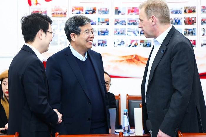 Three men smiling and talking. Source: Peking University