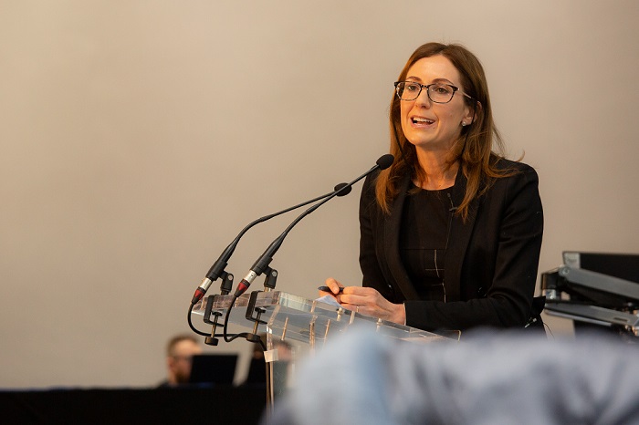 A woman speaking at a podium with microphones. Source: University of Glasgow