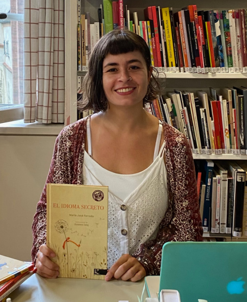 Agustina Palengue sitting at her desk surrounded by books