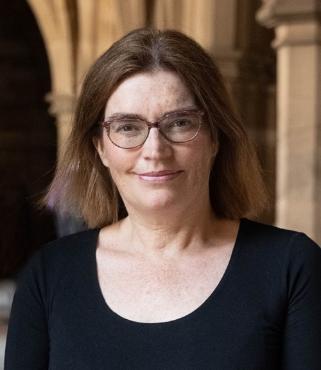 Head and shoulders photo of Nicola McEwan in the Victorian cloisters at the University of Glasgow